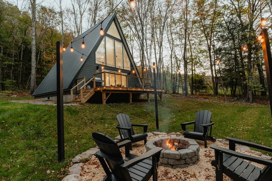 Lagerfeuerstelle mit Steinumrandung und Sitzplätzen vor Ferienhaus
